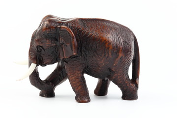 Fototapeta premium Brown elephant made of resin like wood carving with candle holder with white ivory. Stand on white background, Isolated, Art Model Thai Crafts, For decoration Like in the spa.