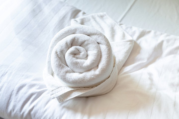 Fototapeta na wymiar Rose Shape Towel decoration on the Clean White Bed