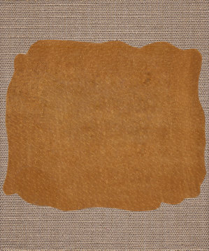 Piece of leather on the fabric textile texture background