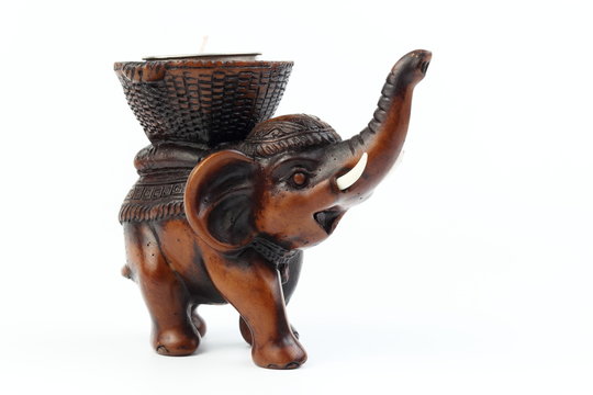 Brown elephant made of resin like wood carving with candle holder with white ivory. Stand on white background, Isolated, Art Model Thai Crafts, For decoration Like in the spa.