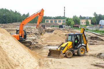 Excavator and tractor on the construction site