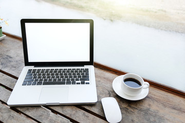 Fototapeta premium Mockup image of laptop with blank white screen on wooden table in terrace nearby river.