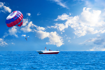 Colorful parasail wing pulled by a boat in the sea water of sunset, Turkey