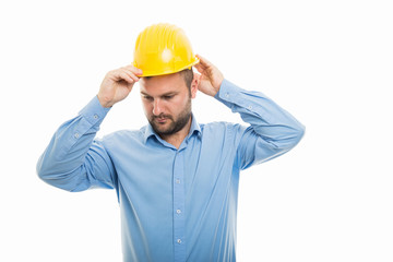 Young architect putting yellow helmet on