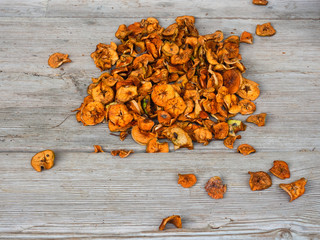 Dried apples piled on rustic old-fashioned wooden table