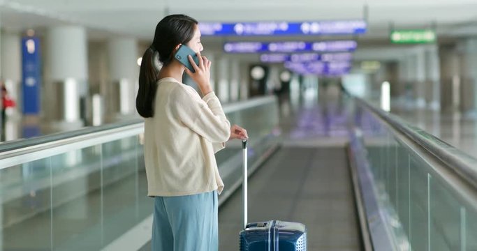 Woman have a call with her luggage at the airport
