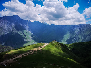 Gergeti trinity church surrounded by great caucasus mountains
