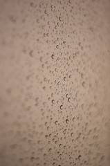 raindrops on window glass on background of cloudy sky
