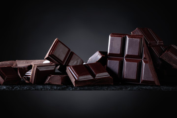 Broken chocolate pieces on a black background.