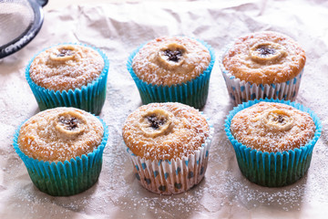 Homemade Banana Nut Muffin with Cinnamon and icing Blue paper case Baked paper background. Selective focus.