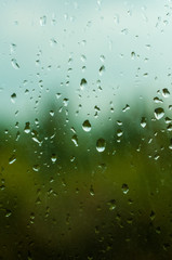 raindrops on window glass on background of cloudy sky