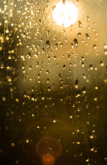 raindrops on window glass on background of cloudy sky