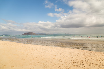 Fototapeta na wymiar Surf school students in the waves of Fuerteventura, Canary Islands, Spain.