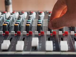 Adjusting buttons on audio mixer