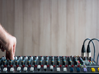 Adjusting buttons on audio mixer in studio