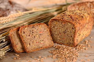 Vollkornbrot mit Getreide, angeschnitten, Brotscheiben, mit Brotlaib im Hintergrund, auf...
