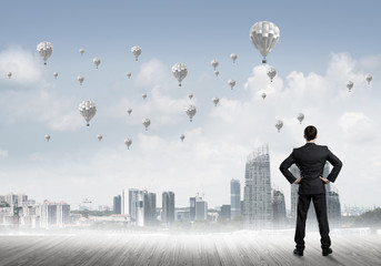 Motivation and inspiration concept with modern cityscape and businessman observing it