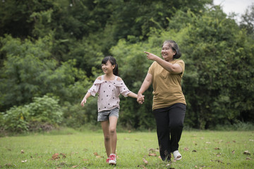 Grandmother Playing With Granddaughter Outdoors At The Park