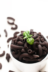 Food concept Squid ink or black penne pasta in white cup on white background