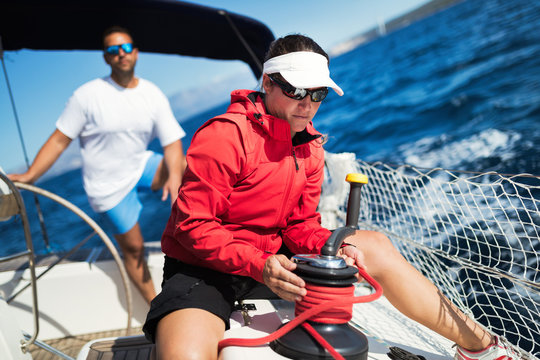 Attractive strong woman sailing with her boat