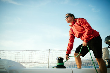 Attractive strong woman sailing with her boat