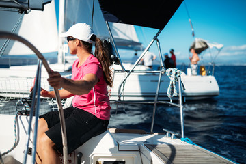 Happy strong woman sailing with her boat