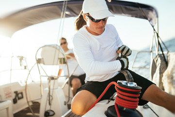 Attractive strong woman sailing with her boat - obrazy, fototapety, plakaty