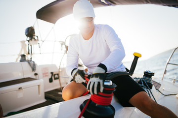 Attractive strong woman sailing with her boat