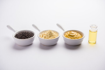 Rai or raw Mustard with sauce, powder and oil, over moody background. Selective focus
