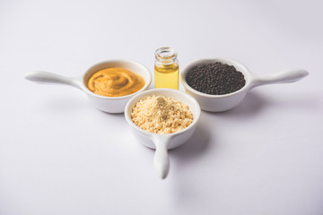 Rai or raw Mustard with sauce, powder and oil, over moody background. Selective focus
