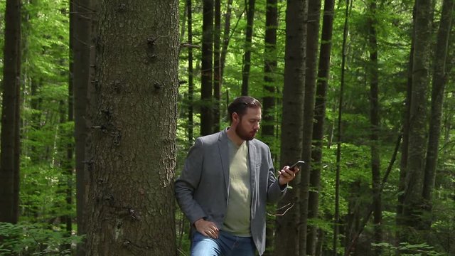 Casual business man lost in the forest with no phone signal. Concept for business challenge
