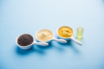 Rai or raw Mustard with sauce, powder and oil, over moody background. Selective focus

