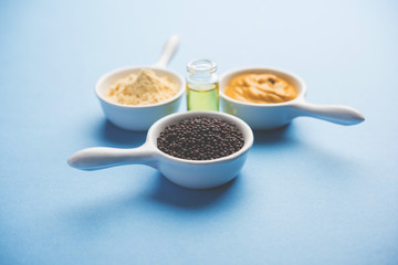 Rai or raw Mustard with sauce, powder and oil, over moody background. Selective focus
