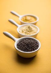 Rai or raw Mustard with sauce, powder and oil, over moody background. Selective focus
