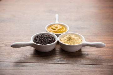 Rai or raw Mustard with sauce, powder and oil, over moody background. Selective focus
