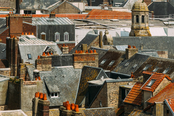 Fototapeta na wymiar Windows, chimneys and roofs of old residential houses in Normandy, France. Old town architecture, beautiful facades, typical french houses. Background
