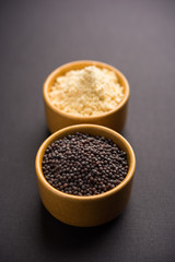 Rai or raw Mustard with sauce, powder and oil, over moody background. Selective focus
