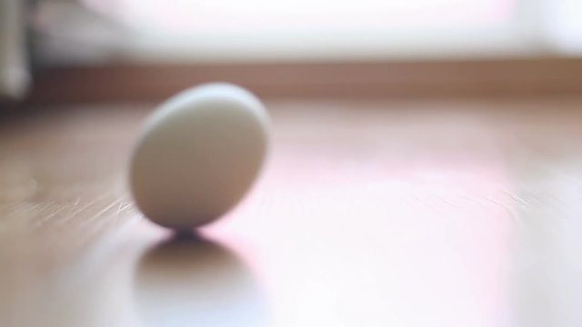 the egg spins on the tile. Video close-up, high quality