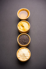 Rai or raw Mustard with sauce, powder and oil, over moody background. Selective focus
