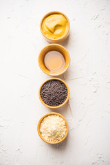 Rai or raw Mustard with sauce, powder and oil, over moody background. Selective focus
