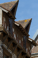 Mansard floor with windows and roof of old residential houses in Normandy, France. Old town architecture, beautiful facades, typical french houses. Background