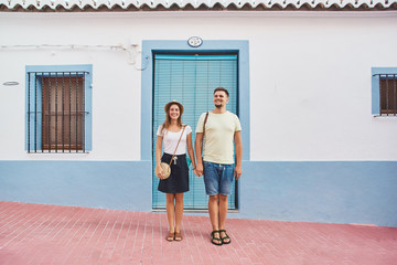 Happy young couple of travellers walking