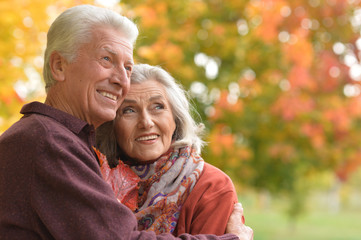 Portrait of happy Senior couple hugging in autumn park