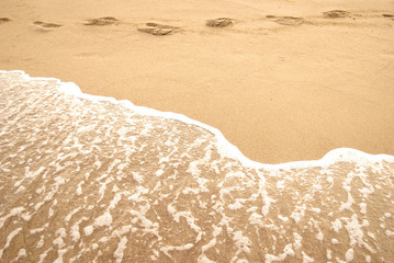summer sea, footprint and foam on a seashore