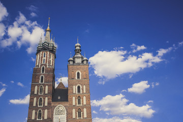 Fototapeta na wymiar medieval old catholic church tower on blue sky cloud background with empty space for copy or text
