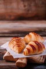 Homemade baked croissants on wooden rustic background