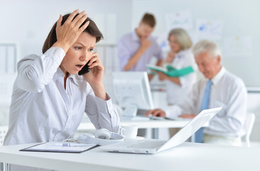 Young woman with headache working in the office