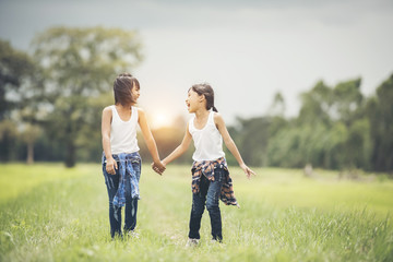 Two little girls hand holding together having fun in the park
