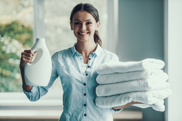 Young Smiling Woman holding Laundry Detergent