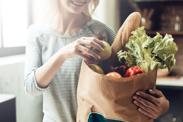 Closeup of Smiling Girl holds Bag of Healthy Food - obrazy, fototapety, plakaty